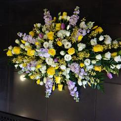 Yellow rose and lilac larkspur casket spray 