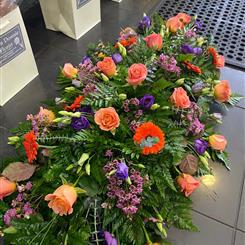 Vibrant coral Rose casket spray 