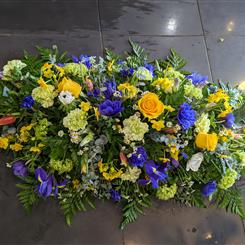 Vibrant yellow and blue casket spray