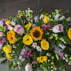 Sunflower and lilac rose casket spray 
