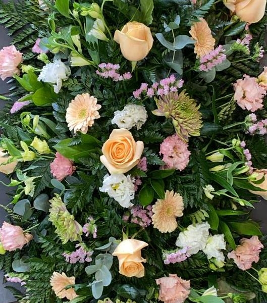 Peach and soft pink casket spray