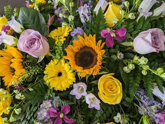 Sunflower and lilac rose casket spray