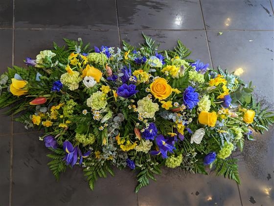 Vibrant yellow and blue casket spray