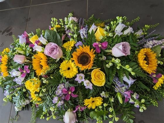 Sunflower and lilac rose casket spray