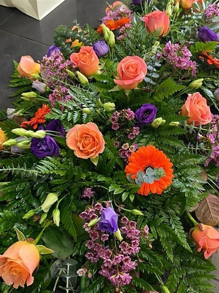 Vibrant coral Rose casket spray