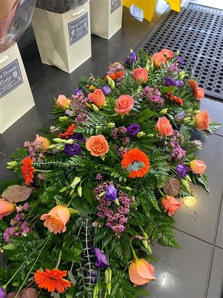 Vibrant coral Rose casket spray
