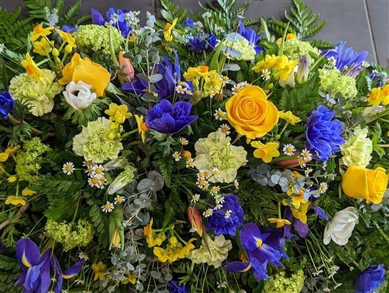 Vibrant yellow and blue casket spray