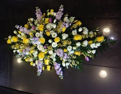 Yellow rose and lilac larkspur casket spray